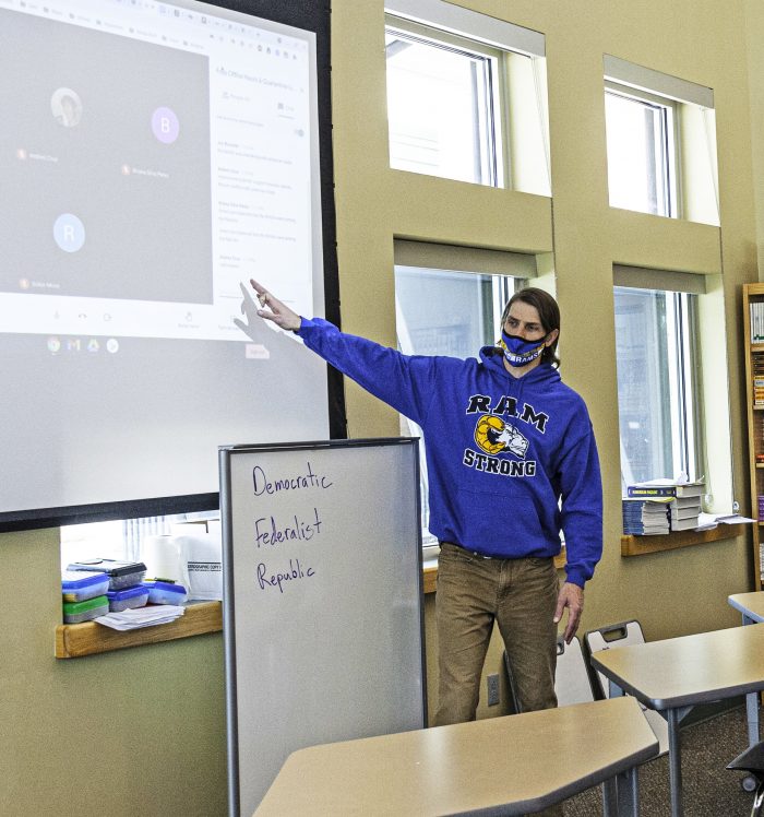Roaring Fork High School social studies teacher Mitch Foss leads a “blended” class (both in-person and distance learners) on United States history. The large video screen brings in students not in the room. Photo by Roberta McGowan.